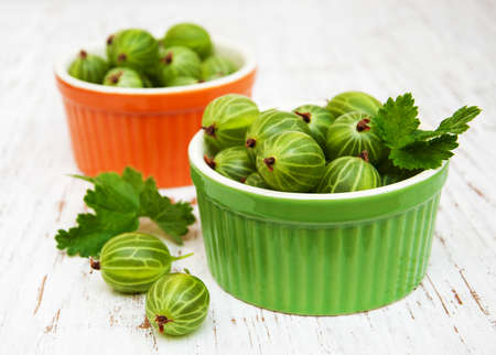 gooseberries with leaves on a old wooden backgroundの写真素材