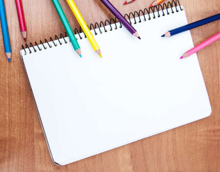 Pencils and notebooks on a wooden tableの写真素材