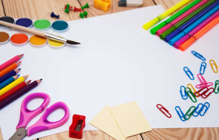 White paper  with school supplies on a wooden backgroundの写真素材
