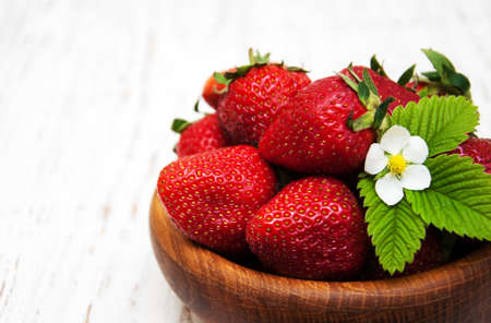 Bowl with strawberries on a old wooden backgroundの写真素材