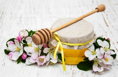 Apples blossom with honey  on a wooden backgroundの写真素材