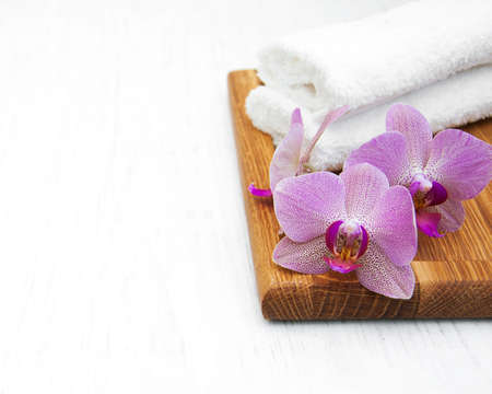 Pink orchids and towels on a wooden backgroundの写真素材
