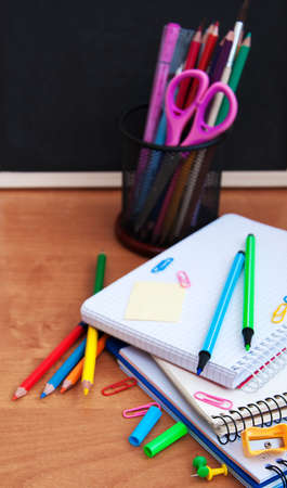 school supplies on a wooden table and  blackboardの写真素材