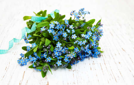 Forget-me-nots flowers with ribbon on a wooden backgroundの写真素材
