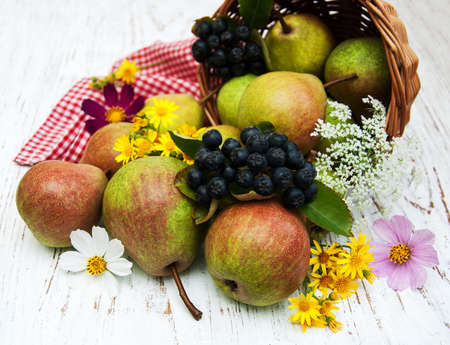 Basket with pears and flowers on a wooden backgroundの写真素材