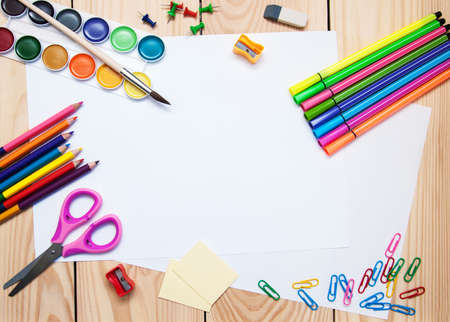White paper with school supplies on a wooden backgroundの写真素材