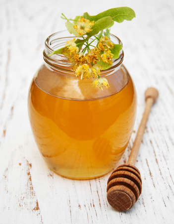 Jar with honey and linden flowers on a wooden backgroundの写真素材