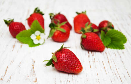 Strawberries with leaves on a wooden backgroundの写真素材