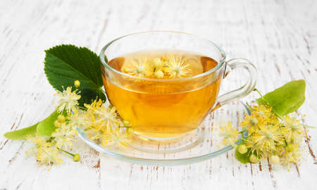 Cup of herbal tea with linden flowers on a old wooden backgroundの写真素材