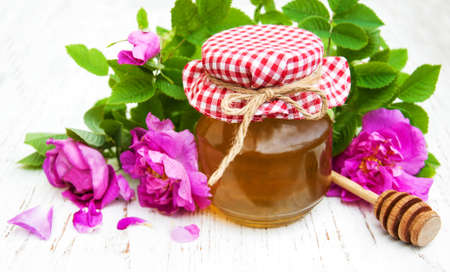 Honey and rose flowers on a old wooden backgroundの写真素材