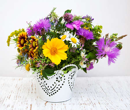 Bucket with Wild flowers  on  a old wooden backgroundの写真素材