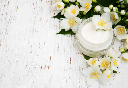 face and body cream moisturizers with jasmine flowers on white wooden backgroundの写真素材
