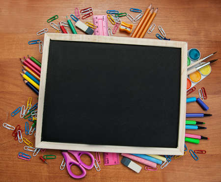 school supplies and blackboard with copy space on the tableの写真素材