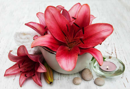 Pink lily, towels and candle on a old wooden backgroundの写真素材