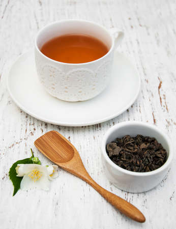 Cup of tea with jasmine flowers on a wooden backgroundの写真素材