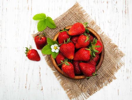 Bowl with strawberries on a old wooden backgroundの写真素材