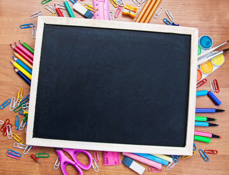 school supplies and blackboard on a wooden backgroundの写真素材