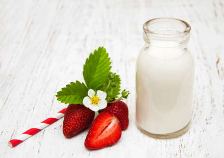 Milk and strawberries on a wooden backgroundの写真素材