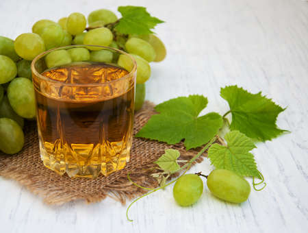 Glass of grape juice on a old wooden backgroundの写真素材