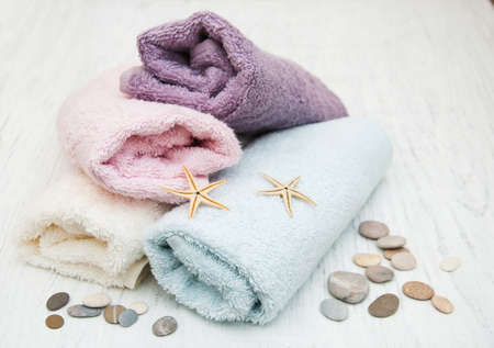 Cotton bath towels with massage stones on a old wooden backgroundの写真素材