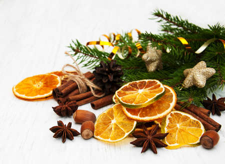 different kinds of spices nuts and dried oranges with christmas treeの写真素材