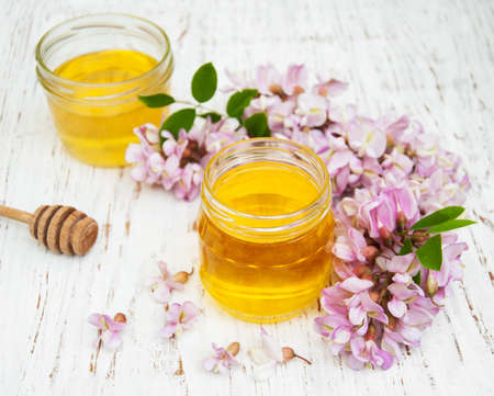 honey with acacia blossoms on a wooden backgroundの写真素材