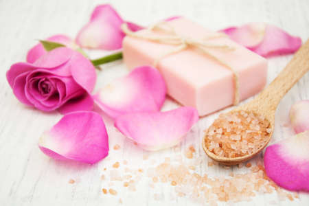 Handmade soap, massage salt and pink rose on a old wooden backgroundの写真素材