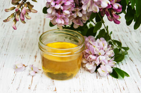 honey with acacia blossoms on a wooden backgroundの写真素材
