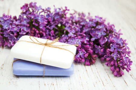 Natural handmade soap and lilac flowers on a wooden backgroundの写真素材
