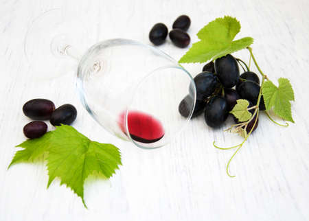 Glass wiyh wine lying on a old wooden backgroundの写真素材