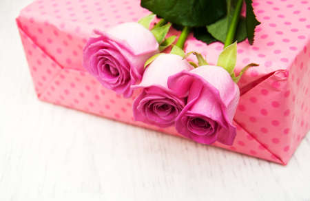 Pink  roses and gift box on a wooden backgroundの写真素材