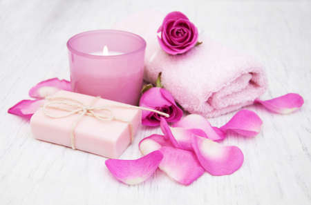 Bath towels, candle and soap with pink roses on a old wooden backgroundの写真素材