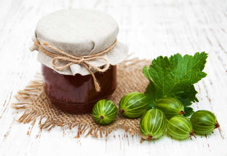 gooseberry jam with fresh berries on a wooden backgroundの写真素材