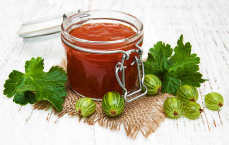gooseberry jam with fresh berries on a wooden backgroundの写真素材