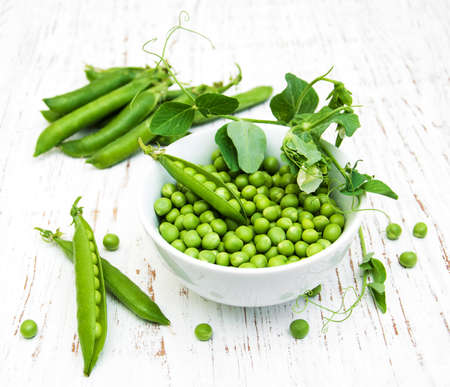 Bowl with fresh peas on a wooden backgroundの写真素材