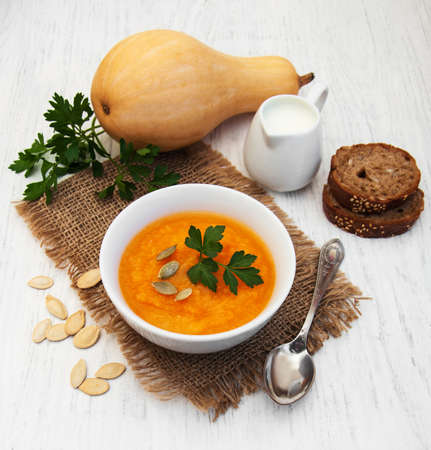 Bowl with Pumpkin soup on a old wooden backgroundの写真素材