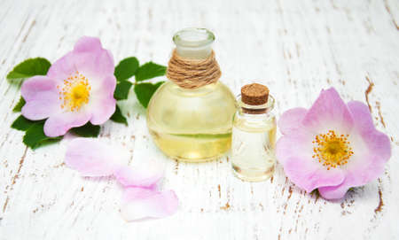 essential oil in glass bottles with dog rose flowersの写真素材