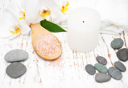 White orchids, candle and salt on a wooden backgroundの写真素材
