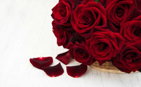 Basket with Fresh Red roses on a old wooden backgroundの写真素材