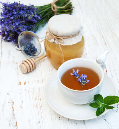 Cup of tea and lavender flowers on a old wooden backgroundの写真素材