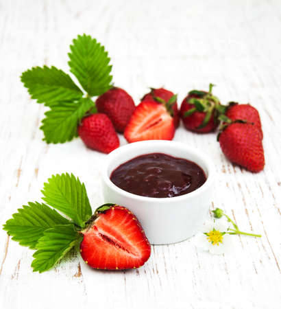 Strawberry jam and fresh strawberries on a wooden backgroundの写真素材