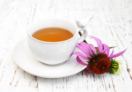 Cup of tea with purple echinacea on a wooden backgroundの写真素材