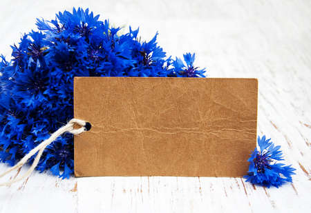 bouquet of blue Cornflowers and card on a old wooden backgroundの写真素材