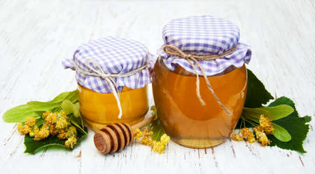 Jars with honey and linden flowers on a wooden backgroundの写真素材