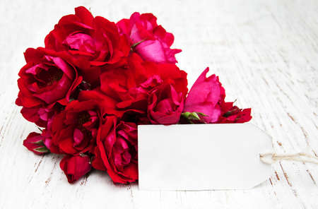 Pink Roses with a card on a old wooden backgroundの写真素材