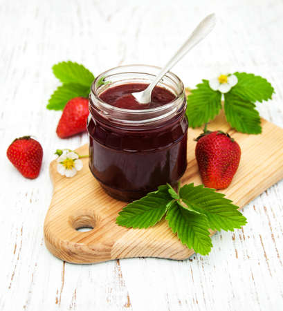 Strawberry jam and fresh strawberries on a wooden backgroundの写真素材