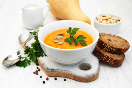 Bowl with Pumpkin soup on a old wooden backgroundの写真素材