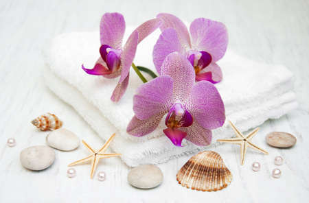 pink orchids, stones  and towel on a wooden backgroundの写真素材