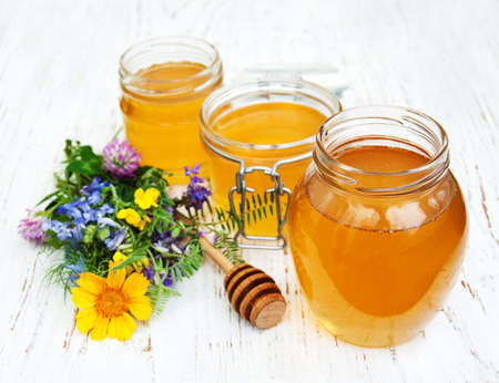 Honey and wild flowers on a wooden backgroundの写真素材