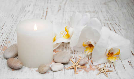 White orchids, candle and salt on a wooden backgroundの写真素材
